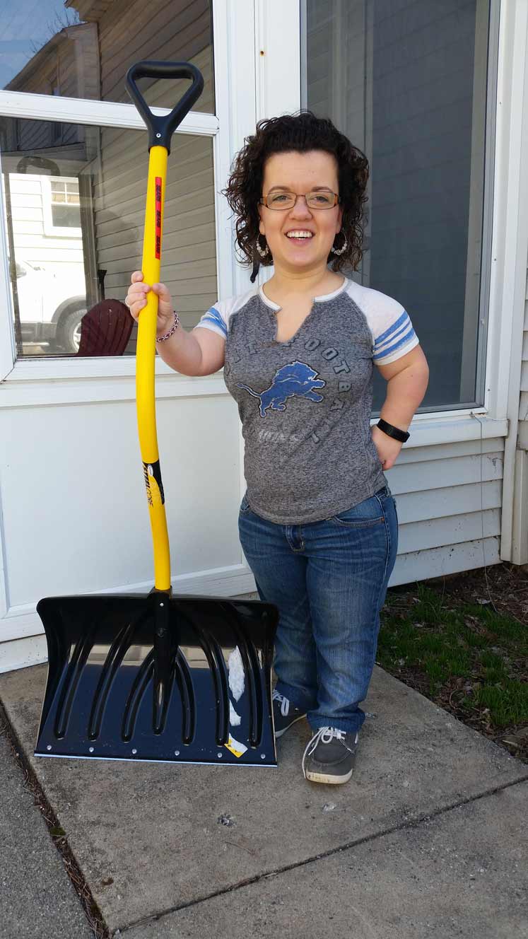 Athina Morehouse standing on porch with snow shovel.