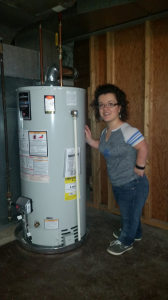 Athina Morehouse standing next to the water heater.